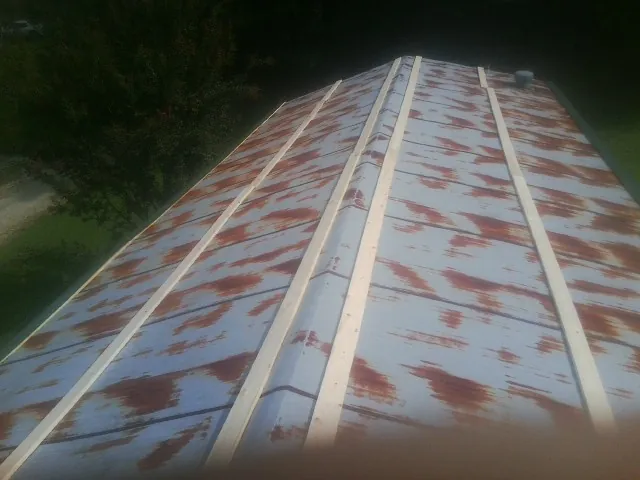 Rusted metal roof panels with new wood purlins before replacement — Storm Damage Roof Repair in Katy by Roofing Brothers