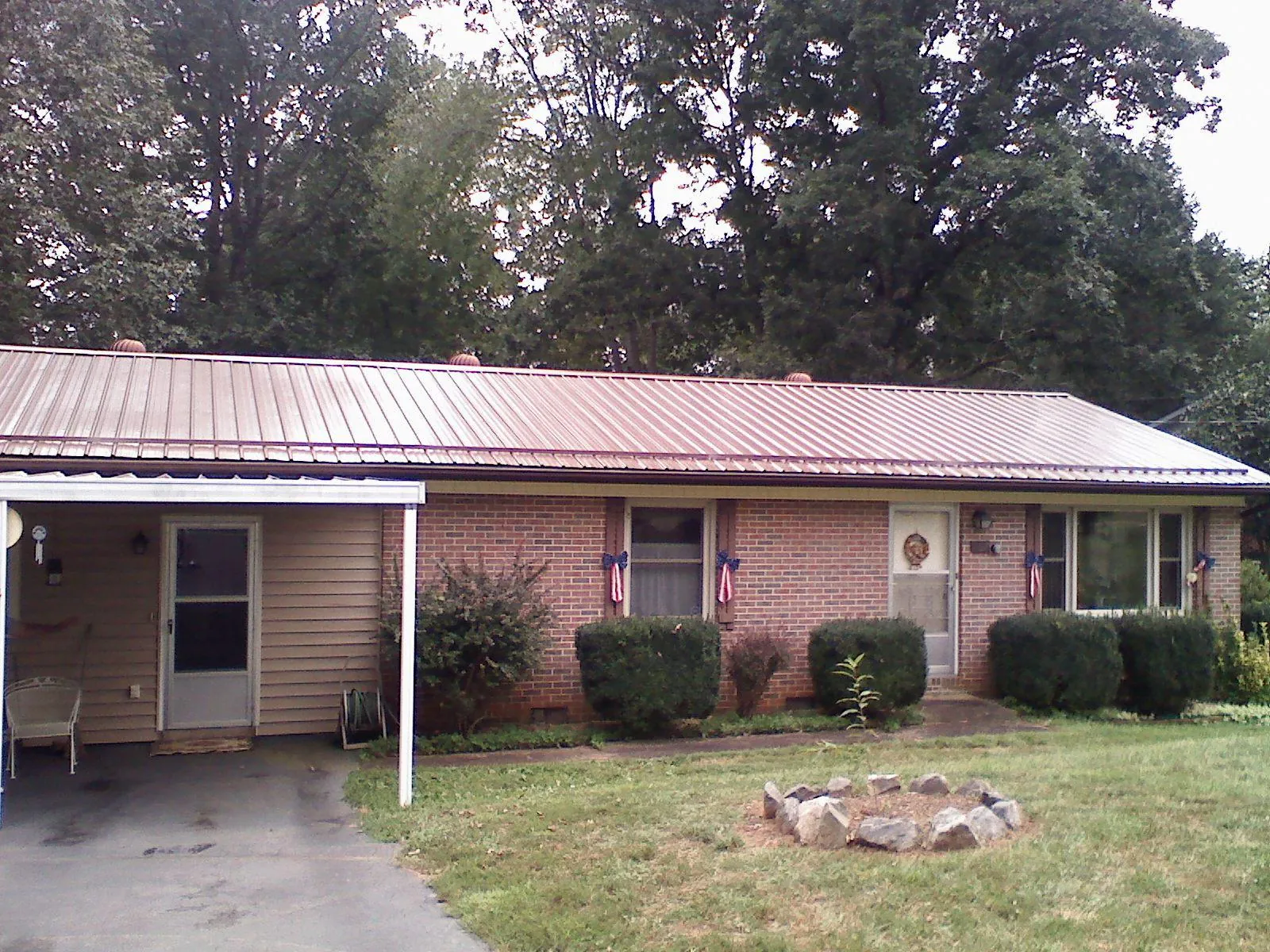 Bronze metal roof and carport on a brick ranch home — Roof Repair work by our crew in Katy
